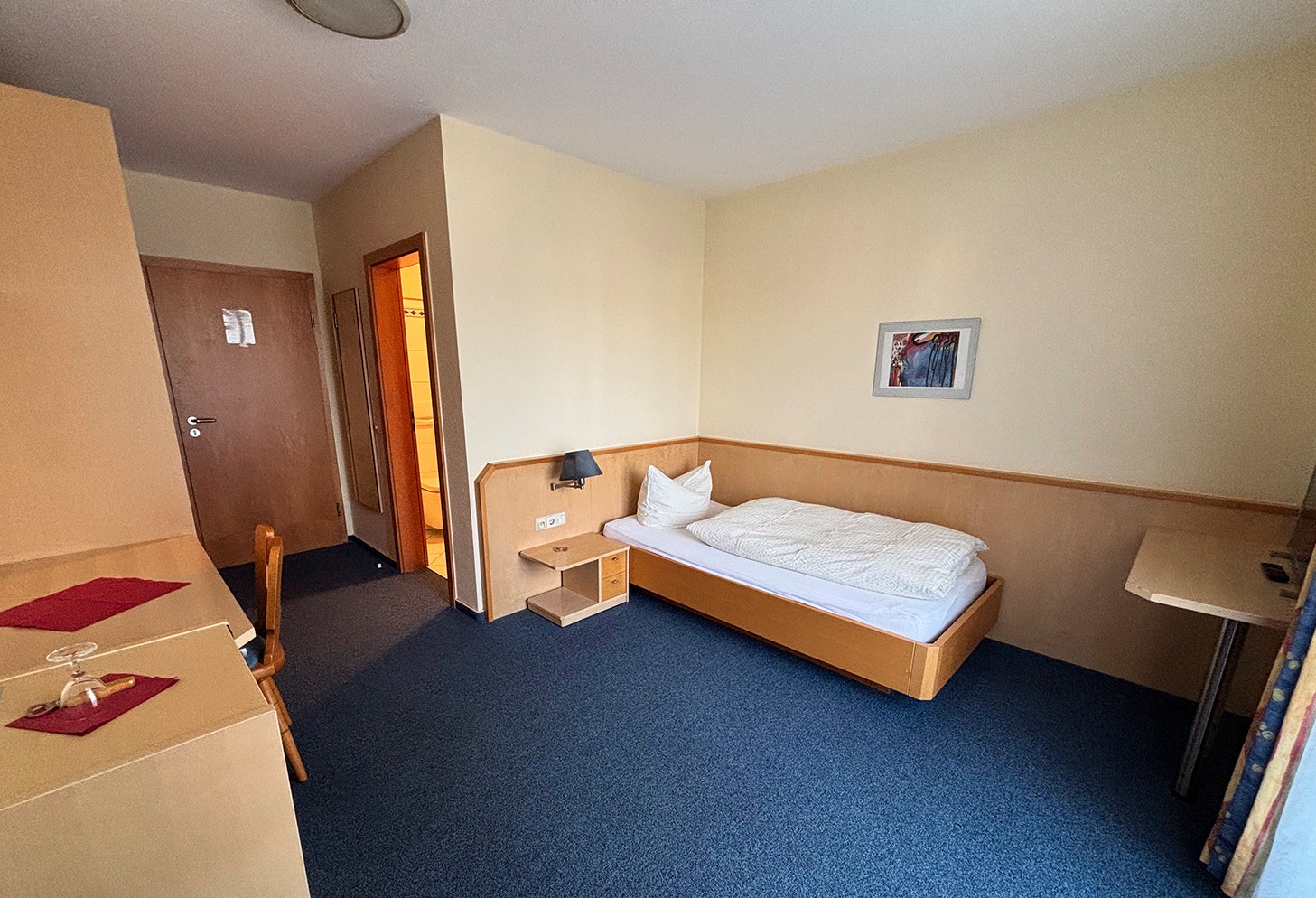 Einzelzimmer mit Schreibtisch und TV
